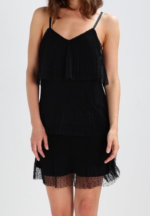 Czarna sukienka z warstwowymi plisami. Cienkie ramiączka, przezroczysta warstwa w kropki oraz falbana na dole. Miękka tekstura i dopasowany krój.