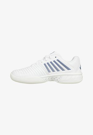 Zapatilla deportiva blanca con rayas horizontales azules, parte superior texturizada y suela curva. Presenta ojetes para cordones y detalles de ventilación laterales.