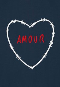 Maglietta blu navy con contorno di cuore ricamato bianco con dettagli di cucitura e la parola "AMOUR" in rosso acceso all'interno del cuore.
