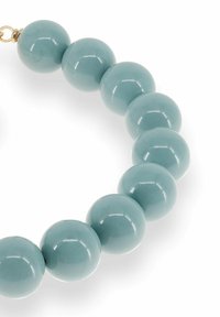 Glossy light blue round beads strung in a curved line with a small gold clasp on a white background.