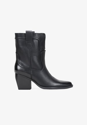 Bota de cuero negra hasta el tobillo con punta cuadrada, un tacón cuadrado y un diseño cosido. Cuenta con una lengüeta en la parte posterior para facilitar el uso.