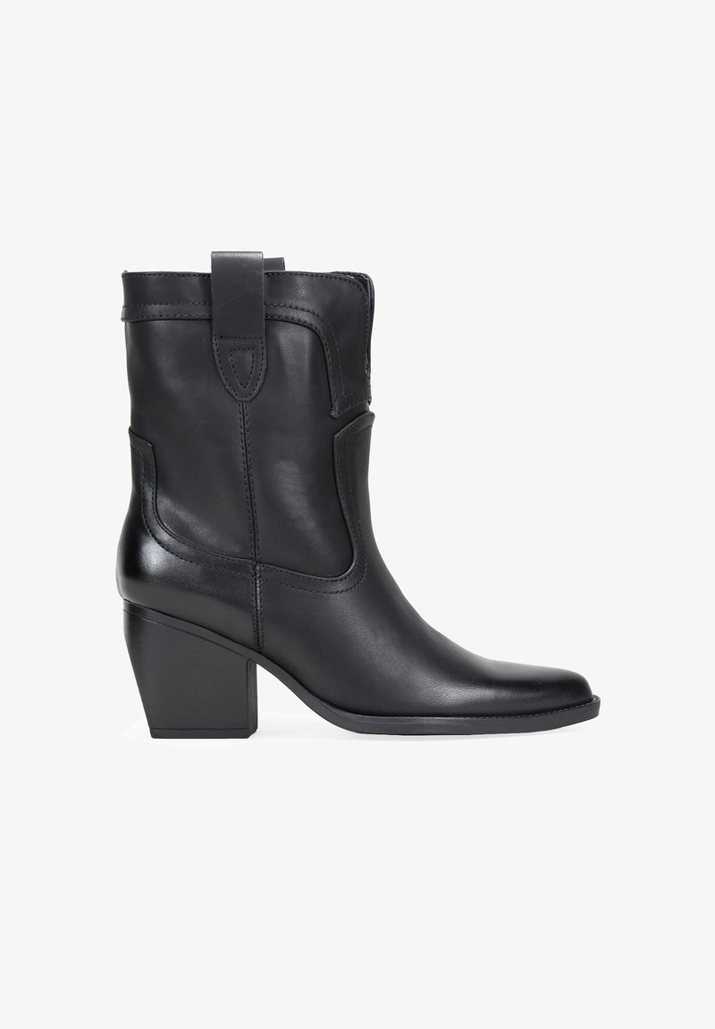 Bota de cuero negra hasta el tobillo con punta cuadrada, un tacón cuadrado y un diseño cosido. Cuenta con una lengüeta en la parte posterior para facilitar el uso.