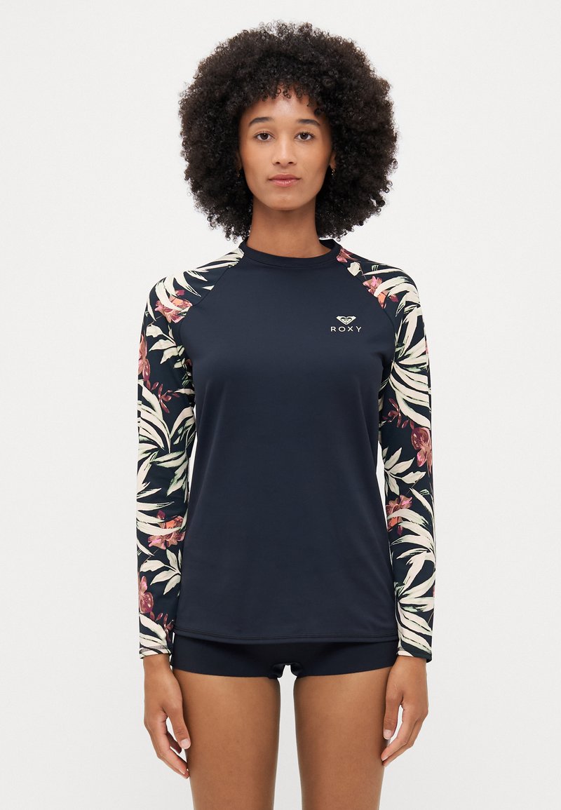 Haut de maillot de bain à manches longues avec un corps bleu marine et des manches à motifs floraux. Fabriqué en tissu extensible avec un logo sur la poitrine.