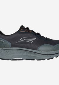 Zapatilla con un upper sintético negro con acentos grises, material texturizado, elementos impermeables y una suela acolchada moteada.