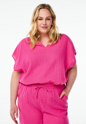 Top rosa largo e morbido a maniche corte con scollatura a V. Realizzato in un tessuto testurizzato, abbinato a pantaloni con vita elastica e tasche.