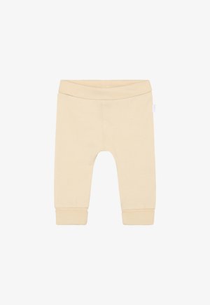 Jasnobeżowe bawełniane legginsy z elastycznym pasem, zwężane przy kostkach, o miękkiej fakturze. Bez wzorów i zdobień.