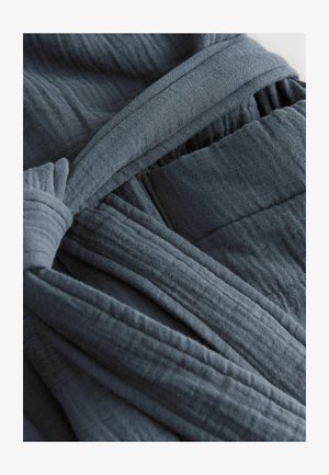 Dunkelgrauer Stoff mit einer weichen, strukturierten Oberfläche. Verfügt über eine verdrehte Schleife und eine Tasche, die geschichtete Falten und einen eleganten Fall präsentieren.