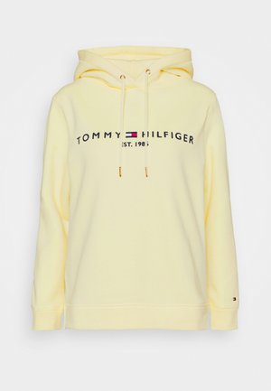 Gele hoodie van katoen, met een logo in zwart met rode en blauwe accenten. Het heeft een capuchon met trekkoord en geribde boorden.