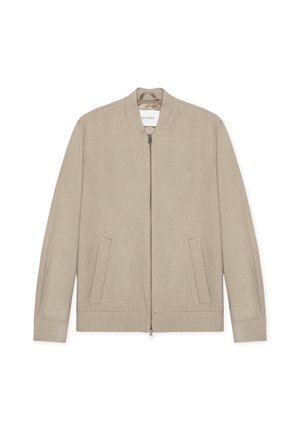 Μπεζ ζακέτα bomber με φερμουάρ μπροστά, στρογγυλή λαιμόκοψη και δύο πλαϊνές τσέπες. Κατασκευασμένη από υφασμάτινη υφή, με διακριτικό λογότυπο στο στήθος.
