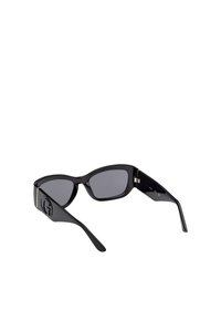 Sorte solbriller med vinklede stel, grå linser og et logo-detalje på stængerne. Lavet af et blankt materiale med en glat overflade.