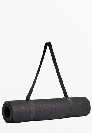 Zrolowana czarna mata do jogi z fakturowaną powierzchnią, zabezpieczona dwoma paskami oraz paskiem na ramię, na białym tle.