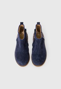 Marineblaue Wildleder-Stiefeletten mit strukturierten Seiten, dekorativen Glitzerdetails und beigen Innensohlen. Seitenreißverschlüsse für einfaches Anziehen.