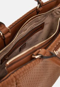 Borsa in pelle intrecciata marrone con molteplici scomparti con cerniera e una fodera interna griffata con un motivo logo ripetuto.