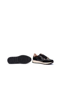 Zapatillas de cuero negro con acentos en rosa, suela de goma texturizada y costuras blancas en contraste. Cuentan con punta redondeada y diseño con cordones.