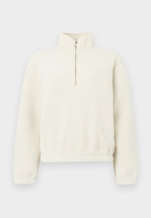 Cremfarbener Fleece-Pullover mit hohem Kragen und einem Front-Reißverschluss. Die Textur ist weich und flauschig und verfügt über gerippte Bündchen und einen Saum.