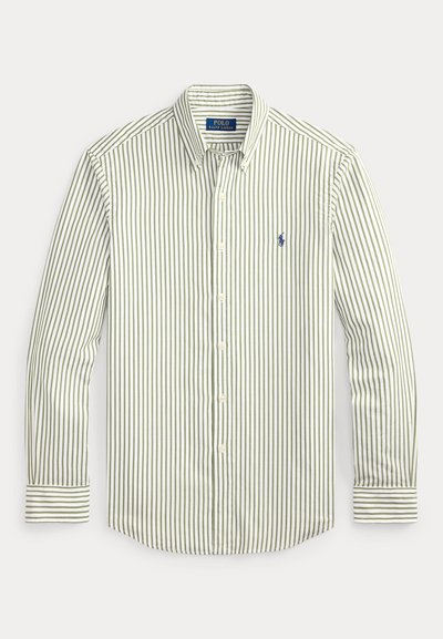 Πουκάμισο με ρίγες σε ανοιχτό πράσινο και λευκό. Διαθέτει κλασικό γιακά, μακριά μανίκια και μικρό ναυτικό λογότυπο στο στήθος.