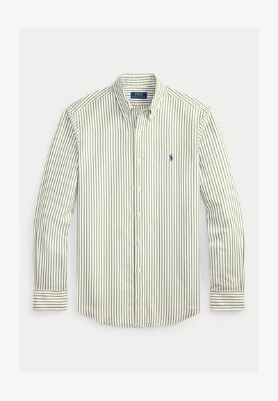 Πουκάμισο με ρίγες σε ανοιχτό πράσινο και λευκό. Διαθέτει κλασικό γιακά, μακριά μανίκια και μικρό ναυτικό λογότυπο στο στήθος.