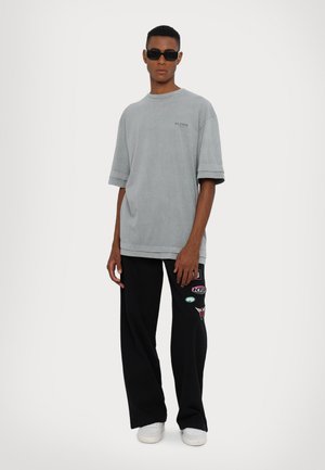 STAMPED UNISEX - Tracksuit bottoms - black