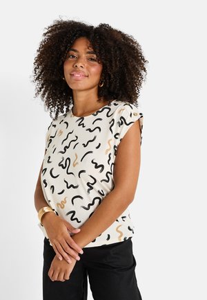 Top de manga corta en crema con patrones negros y dorados en forma de zigzag. Presenta un escote redondeado y botones decorativos en el hombro.