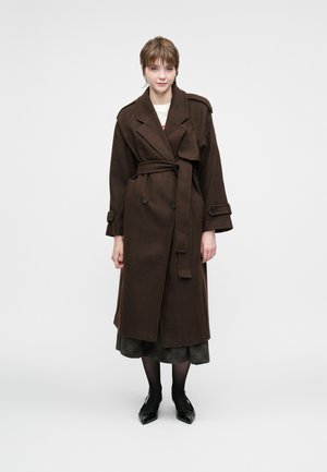 Brun trenchcoat med dobbeltrading foran, bred krage og beltedetalj. Glatt tekstur, lange ermer og store knapper.