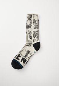 Knee-high socks in a cream color with black comic-style graphics. Features an assortment of figures and elements, with a black toe and heel.