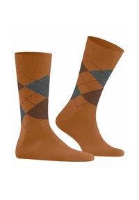 Un paio di calzini alti marroni con un motivo a rombi argyle in arancione, grigio e marrone scuro nella parte superiore.