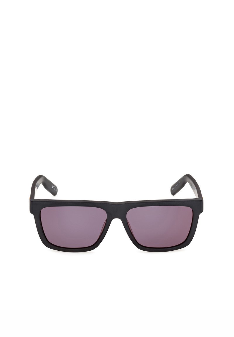 Gafas de sol rectangulares negras con montura gruesa y lentes tintadas de color púrpura oscuro, mostradas desde el frente sobre un fondo blanco.