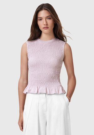 Top senza maniche di un rosa chiaro con texture smock e orlo arricciato. Realizzato in tessuto morbido, presenta un collo rotondo e una silhouette aderente.