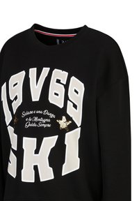 Zwarte sweatshirt met opvallende witte en gouden tekst, stoftextuur en een ontwerp met pailletten en een sterrenmotief.