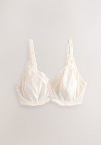 Cream-colored lace bra with underwire and adjustable straps laid flat on a light background.