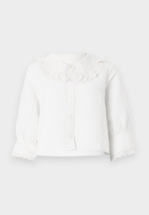 Blouse blanche à manches longues pour bébé avec col et poignets en dentelle festonnée, fermeture à boutons sur le devant et manches légèrement froncées.