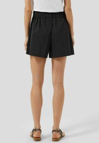 Shorts noirs en tissu léger, avec une taille élastique et une coupe décontractée. Le design présente des lignes simples et épurées sans motifs.