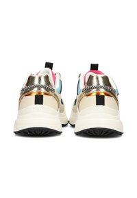 Zapatillas con una combinación de colores beige y dorado metálico, detalles de malla, suela negra prominente y coloridos detalles en la parte trasera.