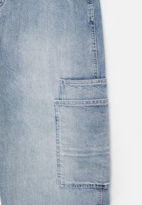 Jasnoniebieskie spodnie cargo z denimu z dużą boczną kieszenią, prostą nogawką i widocznymi detalami przeszyć.