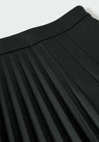 Jupe plissée noire avec une texture lisse et épurée et une large ceinture, mettant en valeur les plis structurés et le design drapé.