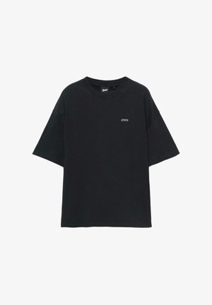 Sort T-shirt i bomuld med løs pasform, rund hals og korte ærmer. Har lille hvid "STWPD" tekst på venstre brystområde.