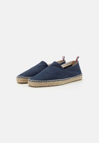 Námornícké plátené espadrilky s jute podrážkou, s okrúhlou špičkou a elastickými bočnými panelmi, zvýraznené tenkými červenými, bielymi a modrými slučkami.