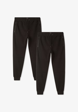 Pantaloni jogger neri realizzati in morbido tessuto elasticizzato. Presentano una vita elasticizzata, cordino e tasche laterali con zip. Design delle gambe affusolate.