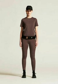 Brown athletic shirt and leggings, black cap, adjustable black belt with orange stripes, worn with black shoes. Sleek, form-fitting design.
