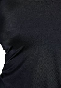 Zwarte stoffen tanktop met een gladde, iets glanzende textuur en een aansluitend ontwerp. Naadloze randen rond de halslijn en armsgaten.