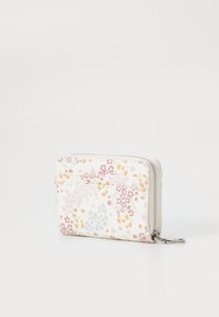 Pung med en hvid stofoverflade, der har et blomsterdesign i pink, orange, blå og grøn. Den har en lynlås og flere kortlommer.
