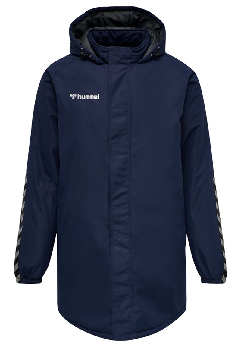 Marinblå lång kappa, vattentåligt material, har en huva, dragkedjestängning och randig detalj på ärmarna; logotyp på bröstet.