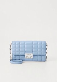 Vaaleansininen tikattu nahkalaukku hopeanvärisillä metalliosilla, jossa ketjuhihna ja erottuva lukko logolla.