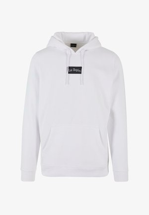 Weißer Kapuzenpullover aus weichem Stoff mit einer Kängurutasche, Kordeln und einem schwarzen Etikett mit dem Aufdruck "Los Angeles" auf der Vorderseite.