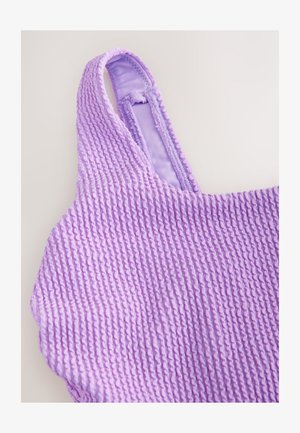 Top violet texturat cu design nervurat, prevăzut cu bretele subțiri și căptușeală interioară netedă. Materialul pare elastic și ușor.