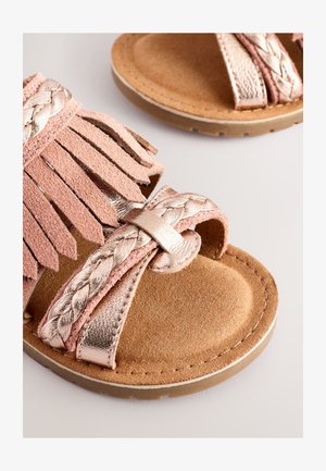 Roze suède sandalen met gevlochten metalen bandjes en franjes. Zachte textuur met een beige binnenzool en een rubberen buitenzool voor grip.