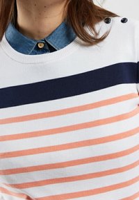 Gestrickter Pullover mit weißem Grund, der horizontale Streifen in Marineblau und Koralle aufweist. Verfügt über einen Denim-Kragen und Knopfakzente an den Schultern.