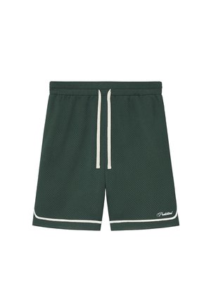 Male legs wearing dark green sports shorts, white crew socks with text, and brown suede loafers on a light gray background.