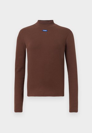 Haut brun à manches longues et col roulé, fabriqué en tissu côtelé. Présente un patch logo bleu sur la poitrine. Design simple avec une silhouette ajustée.