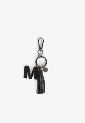 Zwarte sleutelhanger met een glinsterende letter "M", een zwart leren kwastje en een metalen bevestiging met een cirkelvormige hanger.